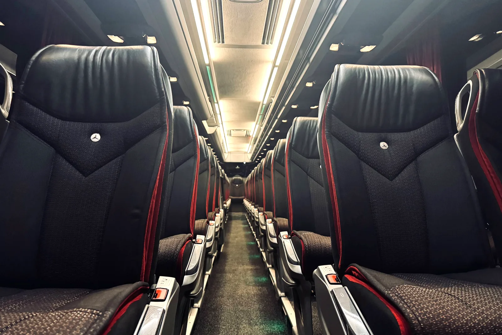Sièges en cuir noir surpiqués de rouge à bord de l'autocar Travego