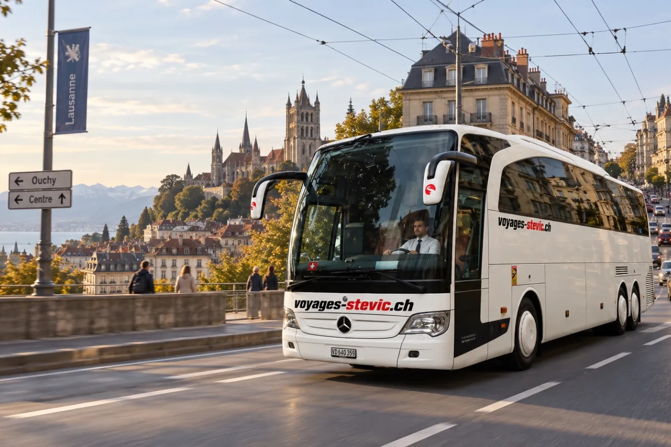 Second autocar Mercedes-Benz Travego de Voyages Stevic Sàrl en circulation à Lausanne, la cathédrale en arrière-plan
